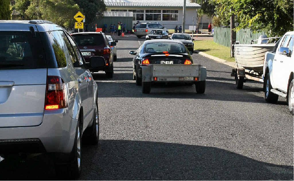 Cars travelling in different directions on Hudson St are unable to do so, so one waits while the other passes.